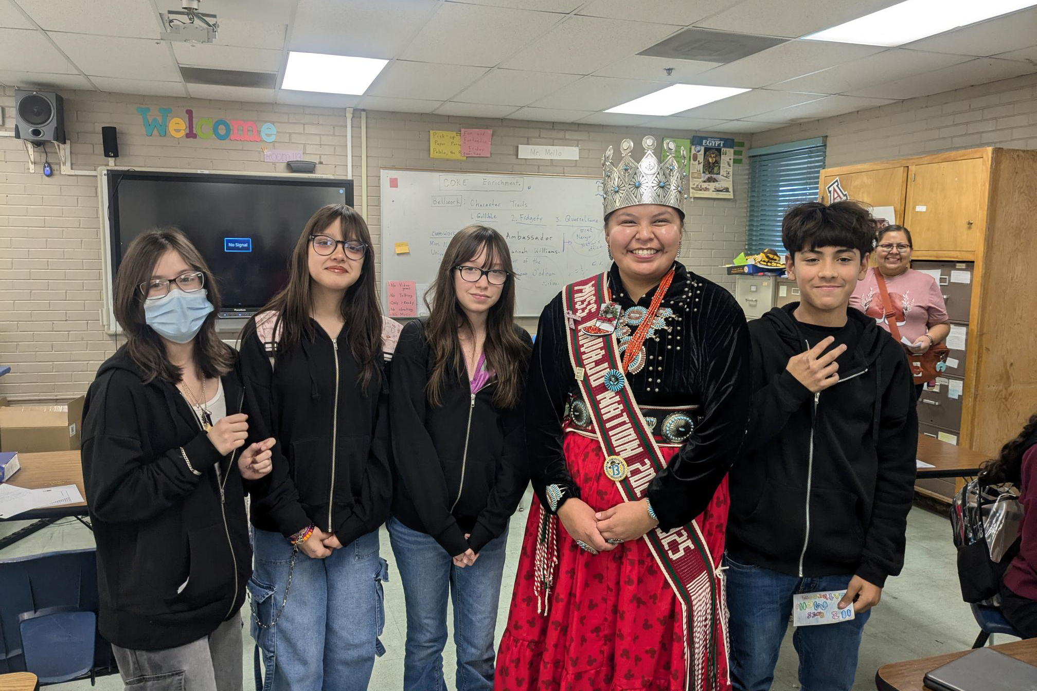 Miss Navajo Nation smiles for a photo with three teen girls and a teen boy