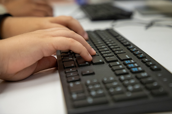 Closeup of a student's hands typing on a keyboard