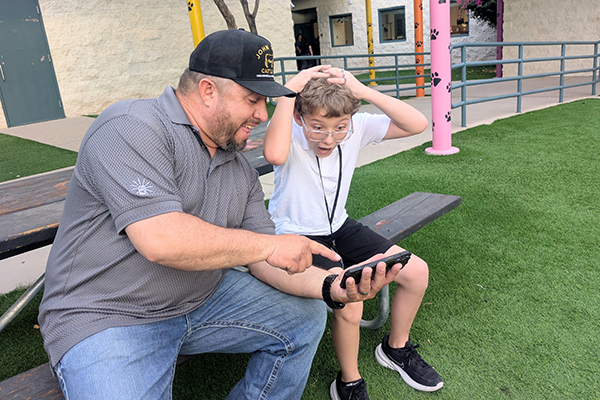A dad and his son excitedly look at a smartphone screen