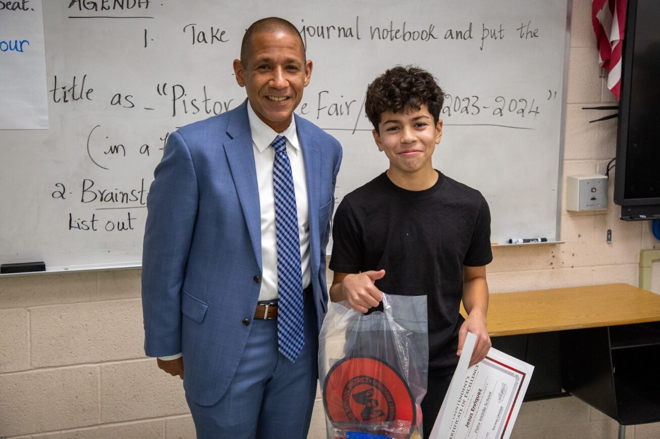 Student Jesus Enriquez smiles next to Dr. Trujillo after receiving his award.